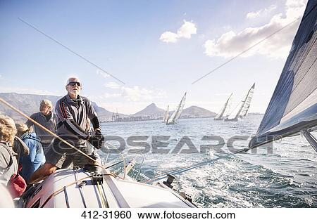 Man adjusting sailboat rigging on sunny ocean View Large Photo Image Stock Image - Man adjusting sailboat rigging on sunny ocean. Fotosearch