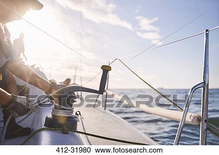 Man adjusting sailing winch on sailboat View Large Photo Image Stock Image - Man adjusting sailing winch on sailboat. Fotosearch
