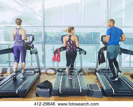 Man and women running on treadmills at gym View Large Photo Image Stock Photograph - Man and women running on treadmills at gym. Fotosearch