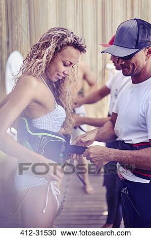 Man fastening kiteboarding safety harness on woman View Large Photo Image Stock Image - Man fastening kiteboarding safety harness on woman. Fotosearch