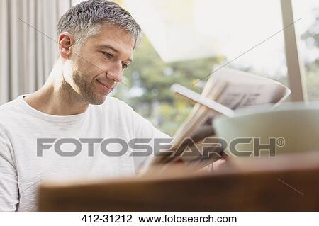 Man reading newspaper at breakfast View Large Photo Image Stock Image - Man reading newspaper at breakfast. Fotosearch
