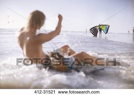 Man ready to kiteboard in ocean surf View Large Photo Image Stock Image - Man ready to kiteboard in ocean surf. Fotosearch