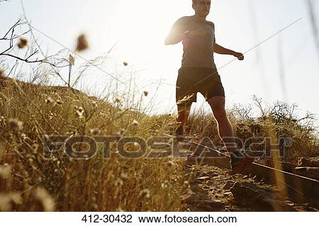 Man running down sunny trail View Large Photo Image Stock Image - Man running down sunny trail. Fotosearch