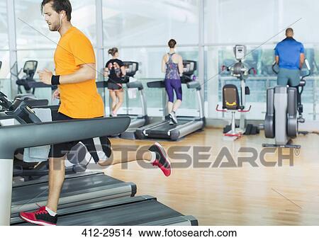 Picture - Man running on treadmill at gym. Fotosearch