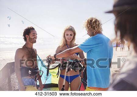 Man teaching woman kiteboarding on sunny beach View Large Photo Image Stock Image - Man teaching woman kiteboarding on sunny beach. Fotosearch