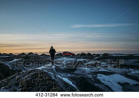 Man walking on icy mounds in remote landscape, Hofn, Iceland View Large Photo Image Picture - Man walking on icy mounds in remote landscape, Hofn, Iceland. Fotosearch