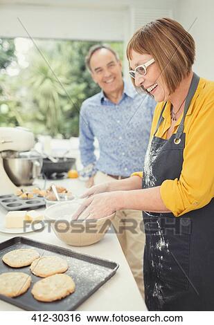 Mature couple baking cookies in kitchen View Large Photo Image Stock Photograph - Mature couple baking cookies in kitchen. Fotosearch