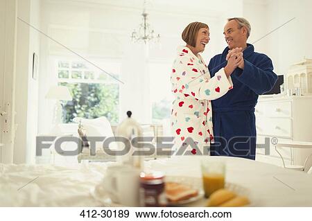 Mature couple dancing in bathrobes in bedroom View Large Photo Image Stock Photo - Mature couple dancing in bathrobes in bedroom. Fotosearch