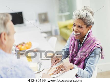 Stock Photo - Mature couple enjoying breakfast at table. Fotosearch