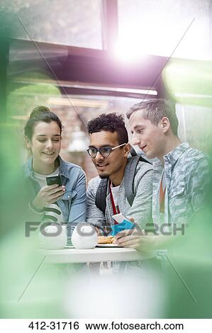 Men and women texting with cell phone in cafeteria View Large Photo Image Stock Photograph - Men and women texting with cell phone in cafeteria. Fotosearch