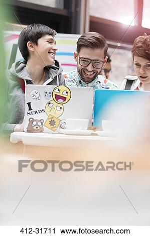 Stock Image - Men and women using laptops at technology conference. Fotosearch