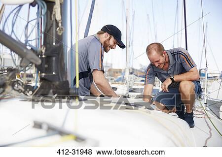 Men preparing sailboat View Large Photo Image Stock Photo - Men preparing sailboat. Fotosearch