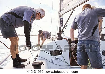 Men sailing adjusting sailboat rigging View Large Photo Image Stock Image - Men sailing adjusting sailboat rigging. Fotosearch