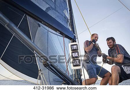 Men sailing pulling rigging equipment on sailboat View Large Photo Image Stock Photograph - Men sailing pulling rigging equipment on sailboat. Fotosearch