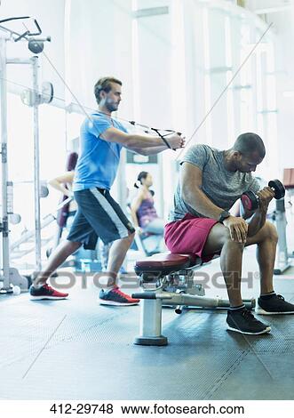 Stock Photo - Men working out at gym. Fotosearch