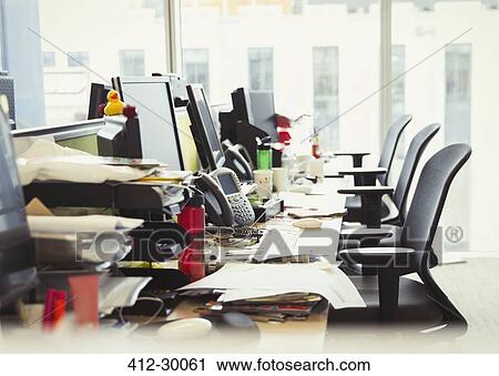 Stock Image - Messy row of desks in office. Fotosearch