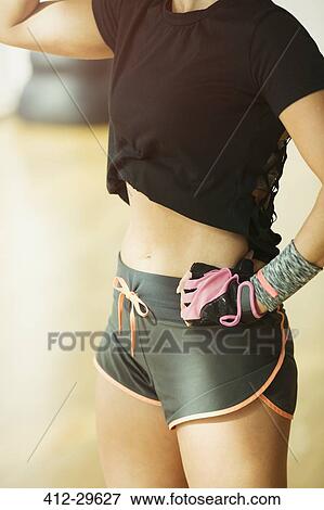 Midsection fit woman wearing short running shorts at gym View Large Photo Image Stock Photo - Midsection fit woman wearing short running shorts at gym. Fotosearch