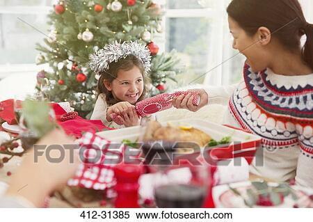 Mother and daughter pulling Christmas cracker at dinner table View Large Photo Image Stock Photography - Mother and daughter pulling Christmas cracker at dinner table. Fotosearch