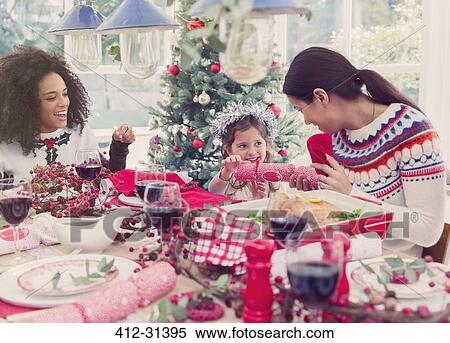 Mother and daughter pulling Christmas cracker at dinner View Large Photo Image Stock Photography - Mother and daughter pulling Christmas cracker at dinner. Fotosearch
