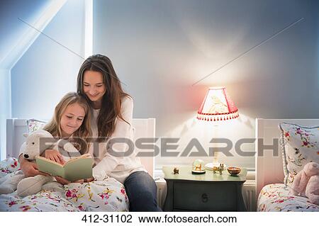 Mother and daughter reading book in bedroom View Large Photo Image Stock Image - Mother and daughter reading book in bedroom. Fotosearch
