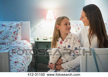 Mother and daughter talking at bedtime in bedroom View Large Photo Image Stock Image - Mother and daughter talking at bedtime in bedroom. Fotosearch