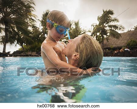Stock Photo - Mother and son hugging in swimming pool. Fotosearch