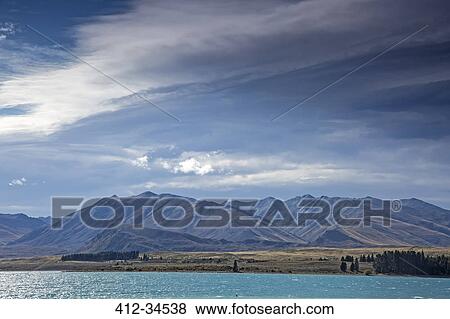 Mountains beyond sunny lake, Lake Tekapo, South Island, New Zealand View Large Photo Image Stock Photo - Mountains beyond sunny lake, Lake Tekapo, South Island, New Zealand. Fotosearch