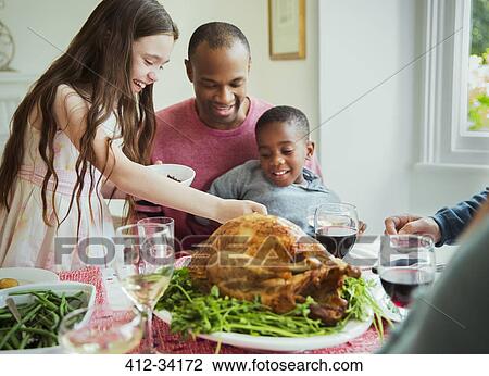 Multi-ethnic family enjoying Christmas turkey dinner at table View Large Photo Image Stock Image - Multi-ethnic family enjoying Christmas turkey dinner at table. Fotosearch