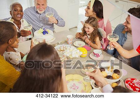Multi-ethnic multi-generation family toasting with champagne at table View Large Photo Image Stock Image - Multi-ethnic multi-generation family toasting with champagne at table. Fotosearch