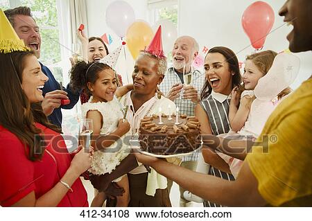 Multi-generation family celebrating birthday with chocolate cake View Large Photo Image Stock Photo - Multi-generation family celebrating birthday with chocolate cake. Fotosearch