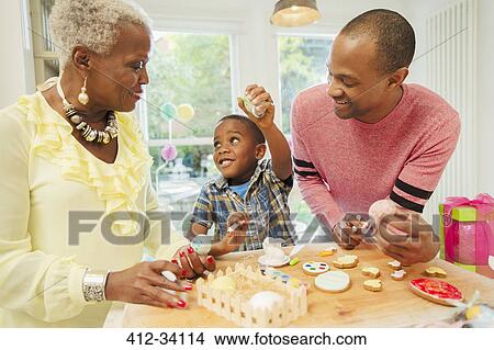 Multi-generation family decorating Easter eggs and cookies in kitchen View Large Photo Image Picture - Multi-generation family decorating Easter eggs and cookies in kitchen. Fotosearch