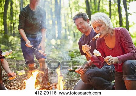 Multi-generation family roasting marshmallows at campfire in forest View Large Photo Image Stock Photograph - Multi-generation family roasting marshmallows at campfire in forest. Fotosearch