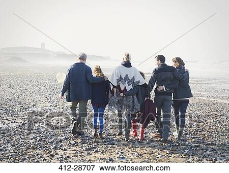 Multi-generation family walking in a row on beach View Large Photo Image Stock Photo - Multi-generation family walking in a row on beach. Fotosearch