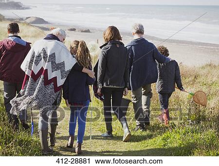 Multi-generation family walking on sunny grass beach path View Large Photo Image Stock Image - Multi-generation family walking on sunny grass beach path. Fotosearch