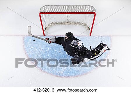 Overhead view hockey goalie reaching to block puck at goal net View Large Photo Image Stock Image - Overhead view hockey goalie reaching to block puck at goal net. Fotosearch