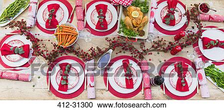 Stock Image - Overhead view of placesettings and food on Christmas dinner table. Fotosearch