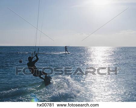 Parasailing on ocean under sunny blue sky View Large Photo Image Stock Image - Parasailing on ocean under sunny blue sky. Fotosearch