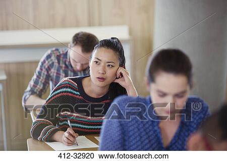 Pensive female college student taking test in classroom View Large Photo Image Stock Image - Pensive female college student taking test in classroom. Fotosearch
