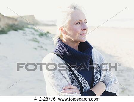 Pensive senior woman looking away on beach View Large Photo Image Stock Photograph - Pensive senior woman looking away on beach. Fotosearch