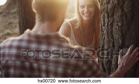 Playful couple at tree in woods View Large Photo Image Stock Image - Playful couple at tree in woods. Fotosearch