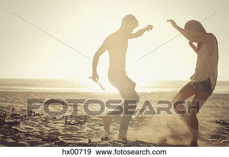 Playful couple dancing on sunny beach at sunset View Large Photo Image Stock Photo - Playful couple dancing on sunny beach at sunset. Fotosearch