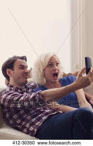 Playful couple making faces taking selfie View Large Photo Image Stock Image - Playful couple making faces taking selfie. Fotosearch