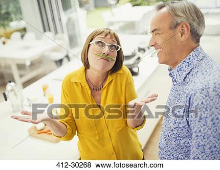 Stock Photo - Playful mature woman with green bean mustache. Fotosearch