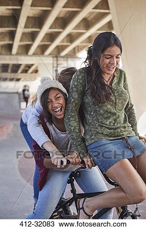 Playful teenage girls riding BMX bicycle at skate park View Large Photo Image Stock Image - Playful teenage girls riding BMX bicycle at skate park. Fotosearch