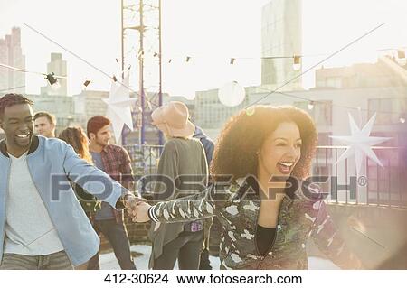Playful young couple at rooftop party View Large Photo Image Picture - Playful young couple at rooftop party. Fotosearch