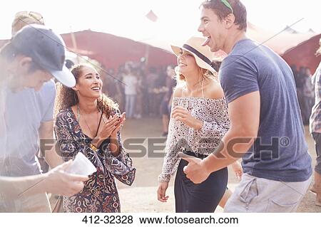 Playful young friends dancing at music festival View Large Photo Image Stock Photo - Playful young friends dancing at music festival. Fotosearch