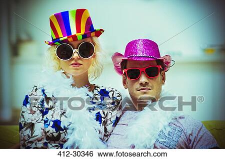 Stock Photograph - Portrait attitude couple wearing costume hats and sunglasses. Fotosearch