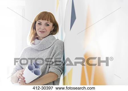 Stock Photo - Portrait confident architect holding blueprints. Fotosearch