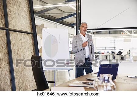 Portrait confident businessman at flipchart in conference room View Large Photo Image Stock Photograph - Portrait confident businessman at flipchart in conference room. Fotosearch