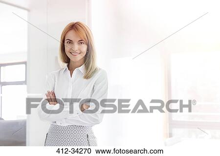 Portrait confident businesswoman in office View Large Photo Image Stock Image - Portrait confident businesswoman in office. Fotosearch